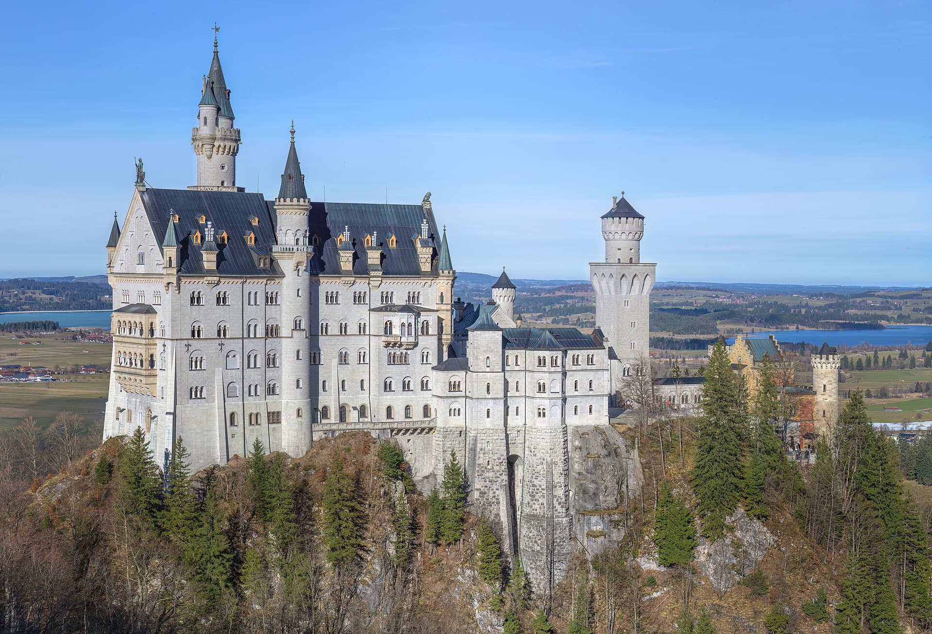 Neuschwanstein Castle above the forested Bavarian foothills, Germany.